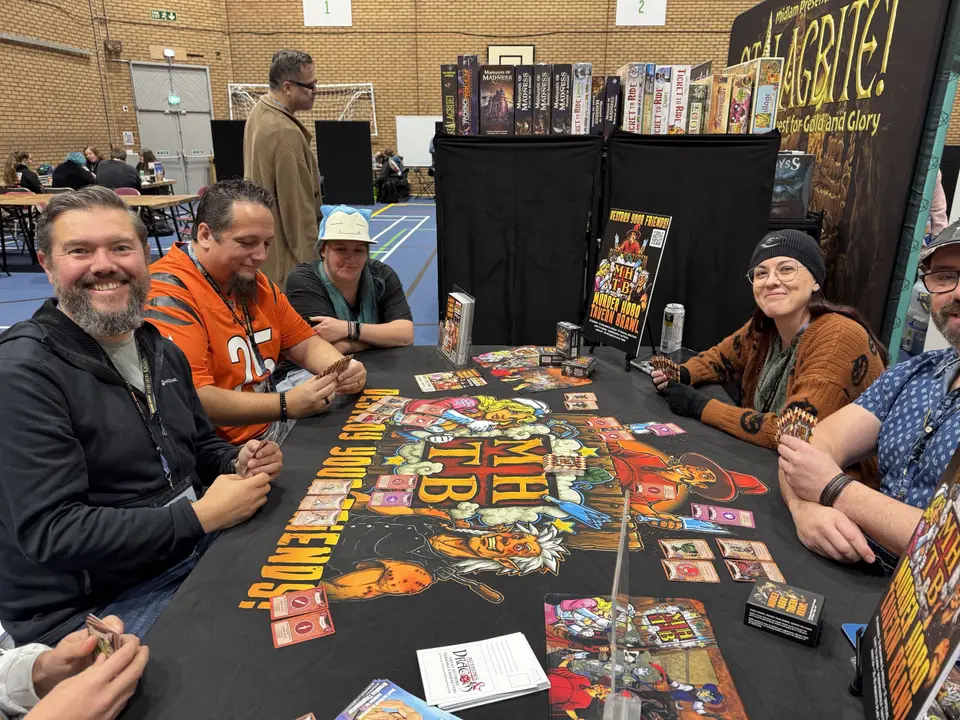 Players trying a new board game at a publisher's demo table